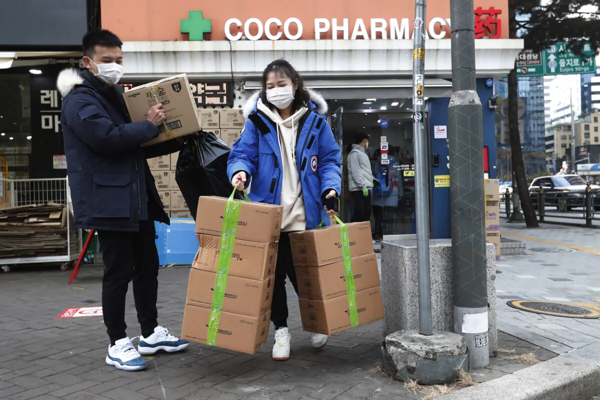 People leave after buying face masks at a pharmacy in Seoul, South Korea, on Jan. 29, 2020. (Ahn Young-joon/AP Photo)