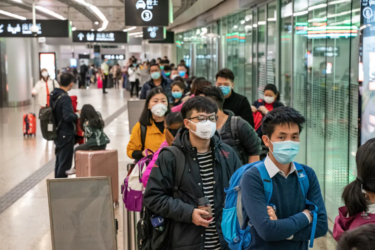 Travelers wearing protective masks wait in line for taxis after arriving at Hong Kong High Speed Rail Station in Hong Kong on Jan. 29, 2020. (Anthony Kwan/Getty Images)