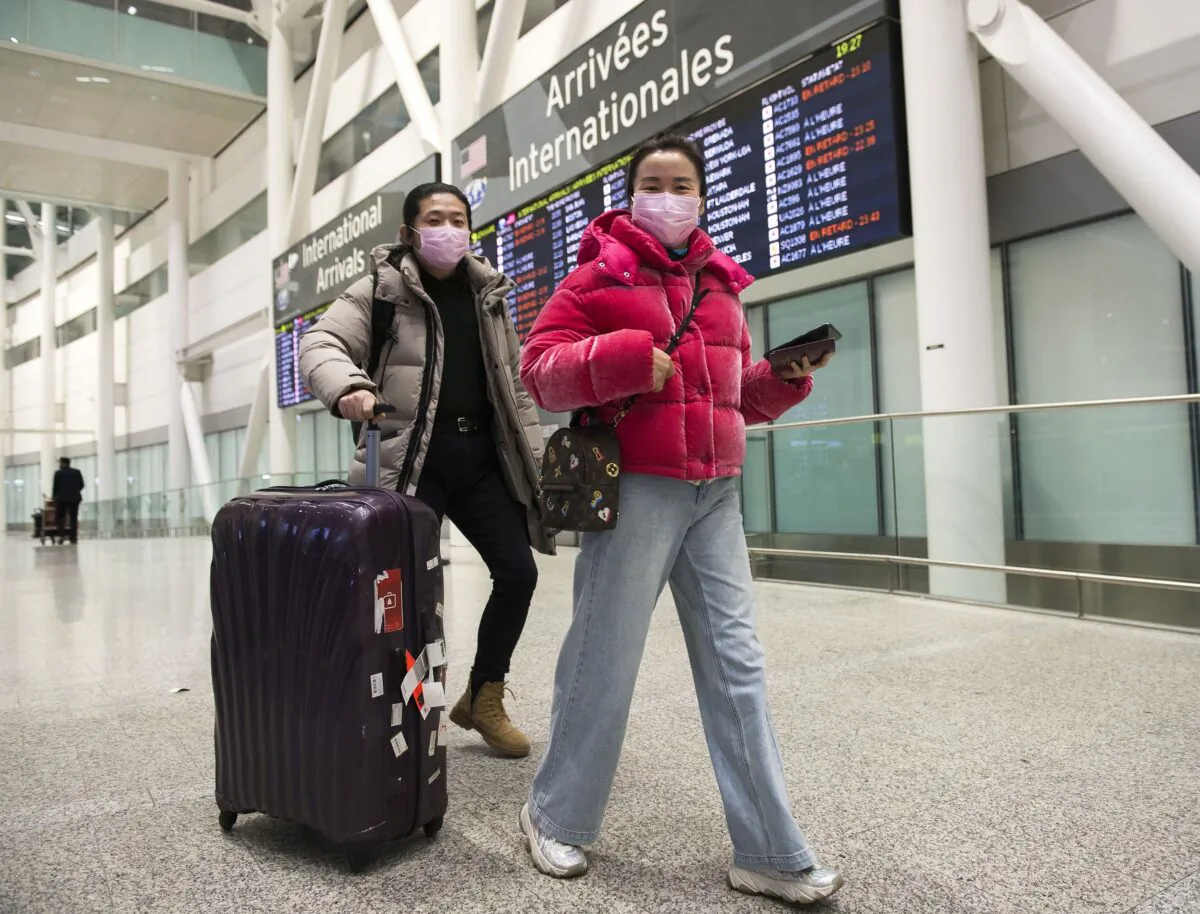 People wear masks as a precaution due to the coronavirus outbreak as they arrive at the International terminal at Toronto Pearson International Airport on Jan. 25, 2020. (The Canadian Press/Nathan Denette)