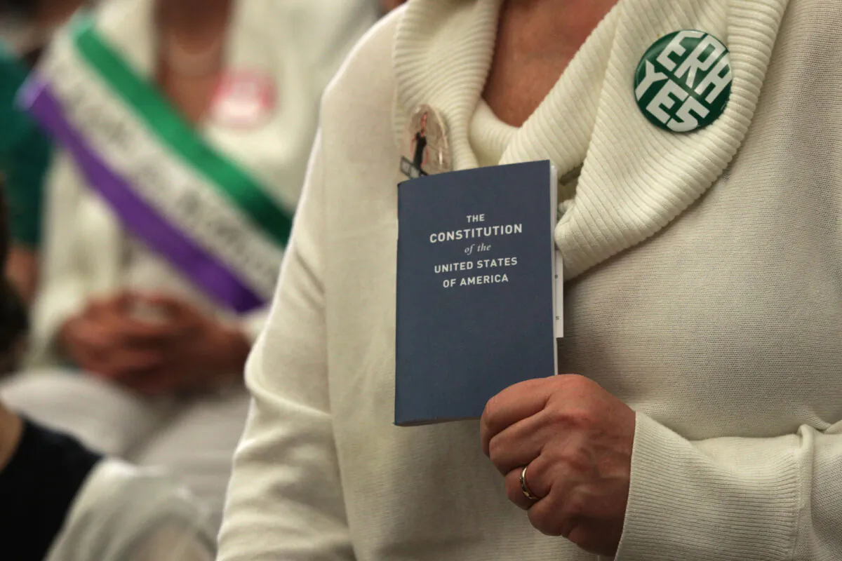 An activist holds a copy of the U.S. Constitution during a news conference on women’s rights on Capitol Hill in Washington, on April 30, 2019. (Alex Wong/Getty Images)
