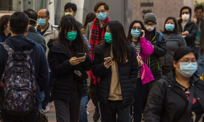People wearing masks walk along a street in Hong Kong on Jan. 30, 2020. (Dale De La Rey/AFP via Getty Images)
