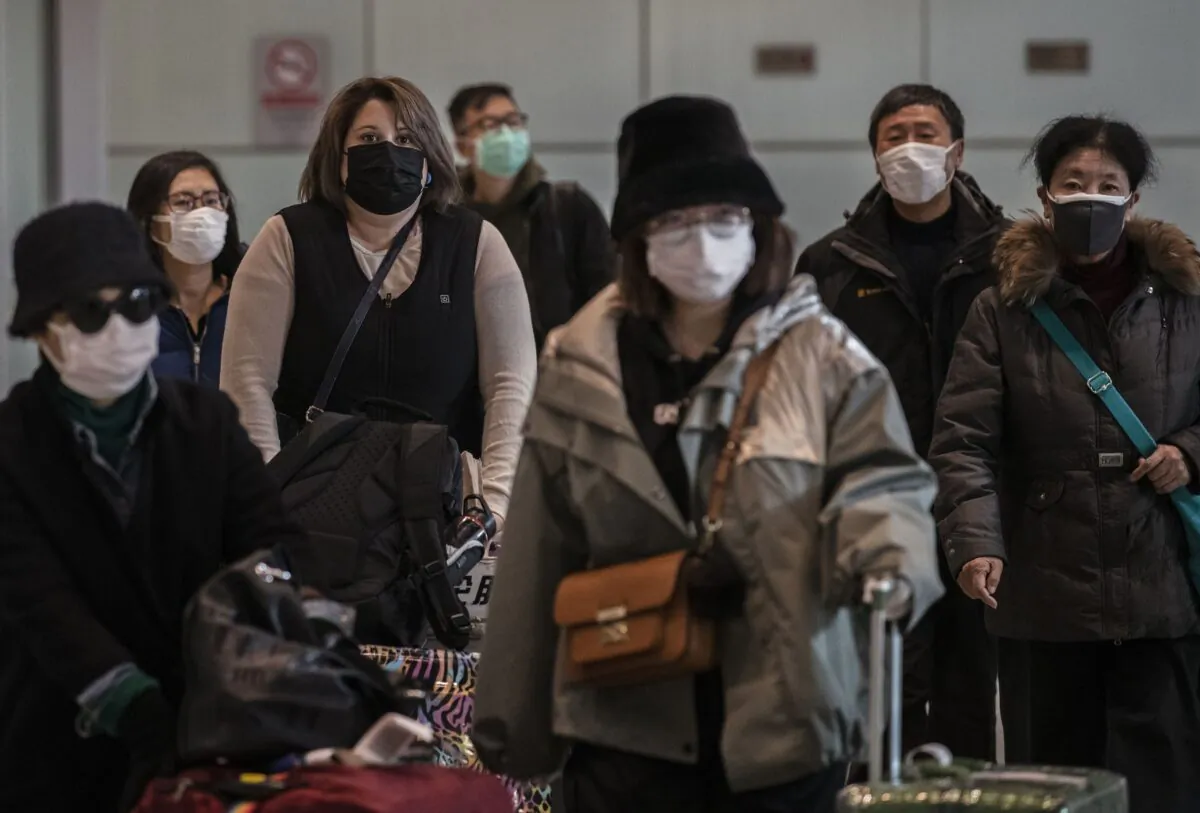 Passengers wear protective masks as they arrive at Beijing Capital Airport in Beijing, China, on Jan. 30, 2020. (Kevin Frayer/Getty Images)