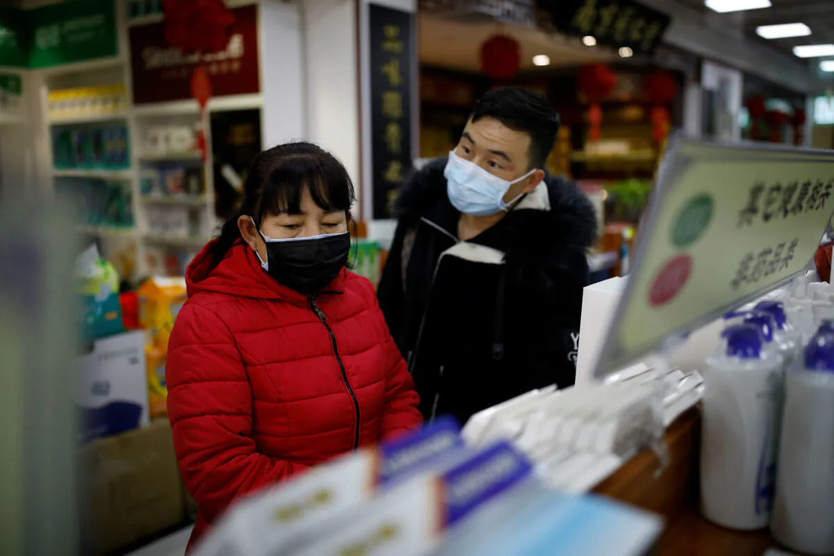 People wearing face masks look for products at a pharmacy as the country is hit by an outbreak of the new coronavirus, in Beijing, China Jan. 30, 2020. (Reuters/Carlos Garcia Rawlins)