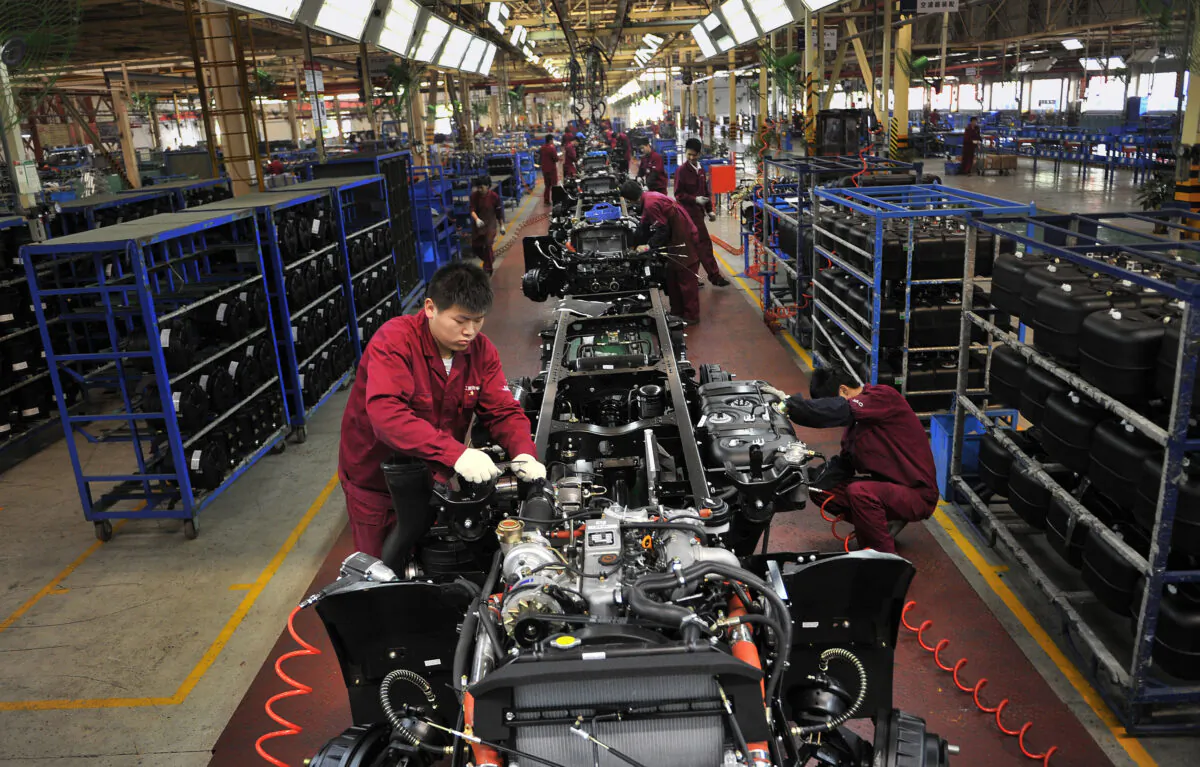 Workers install the chassis along a production line at a truck factory of Anhui Jianghuai Automobile Co. Ltd. (JAC Motors) in Hefei, Anhui Province, China on May 5, 2014. (Reuters)