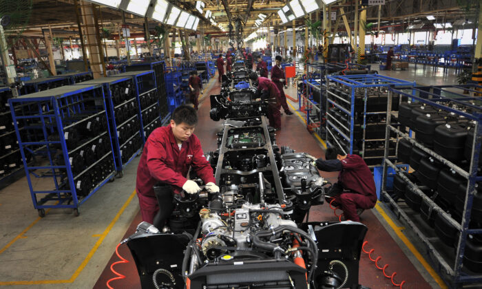 Workers install the chassis along a production line at a truck factory of Anhui Jianghuai Automobile Co. Ltd. (JAC Motors) in Hefei, Anhui Province, China on May 5, 2014. (Reuters)