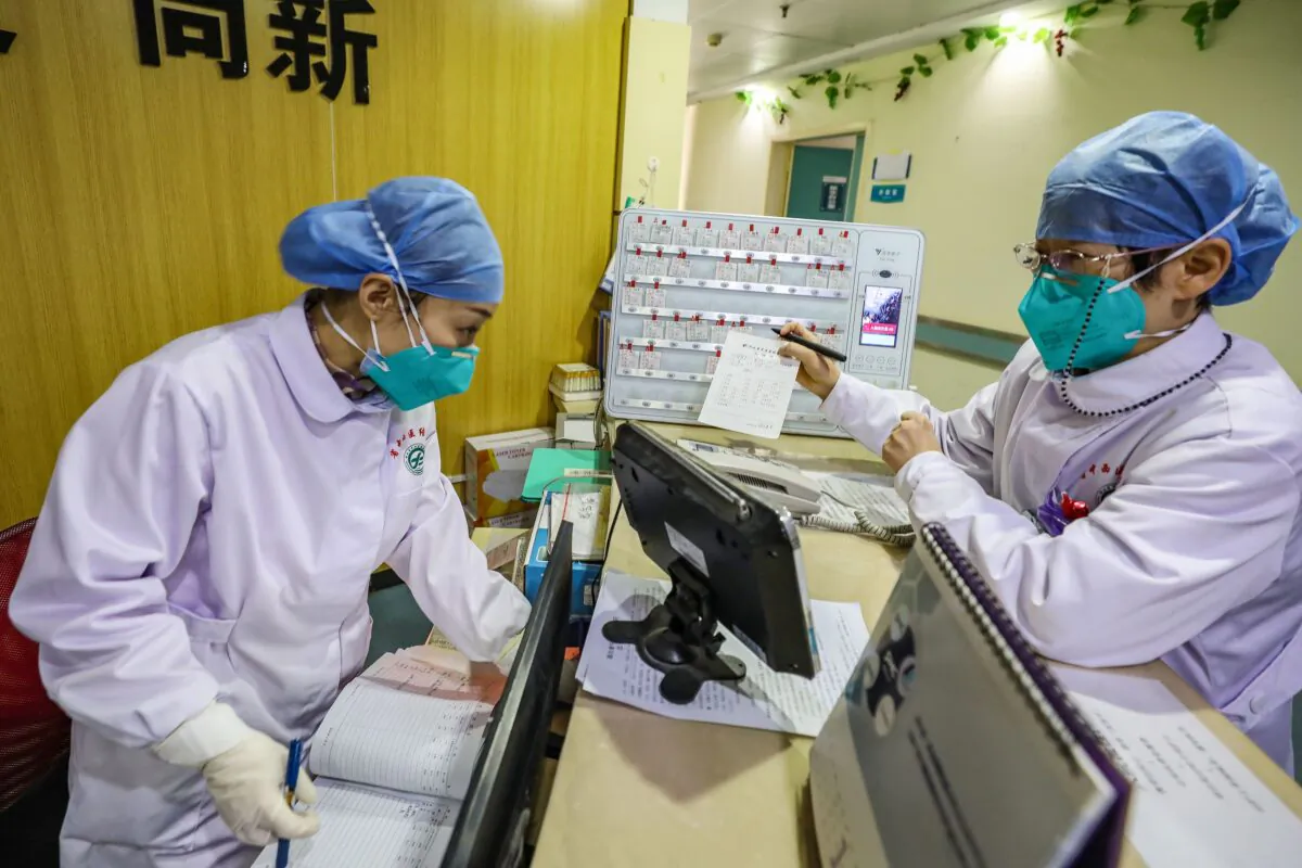 Medical staff members wearing face masks talking at a hospital in Wuhan, China on Jan. 30, 2020. (STR/AFP via Getty Images)