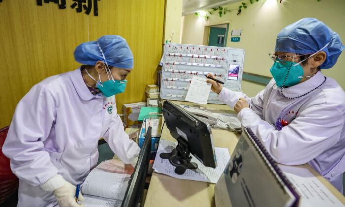 Medical staff members wearing face masks talking at a hospital in Wuhan, China on Jan. 30, 2020. (STR/AFP via Getty Images)