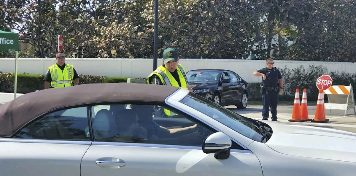 Palm Beach Police and Palm Beach County Sheriff's deputies set up a checkpoint at the intersection of S. County Rd. and S. Ocean Blvd. Friday in Palm Beach, Fla., on Jan. 31, 2020. (Damon Higgins/The Palm Beach Post via AP)