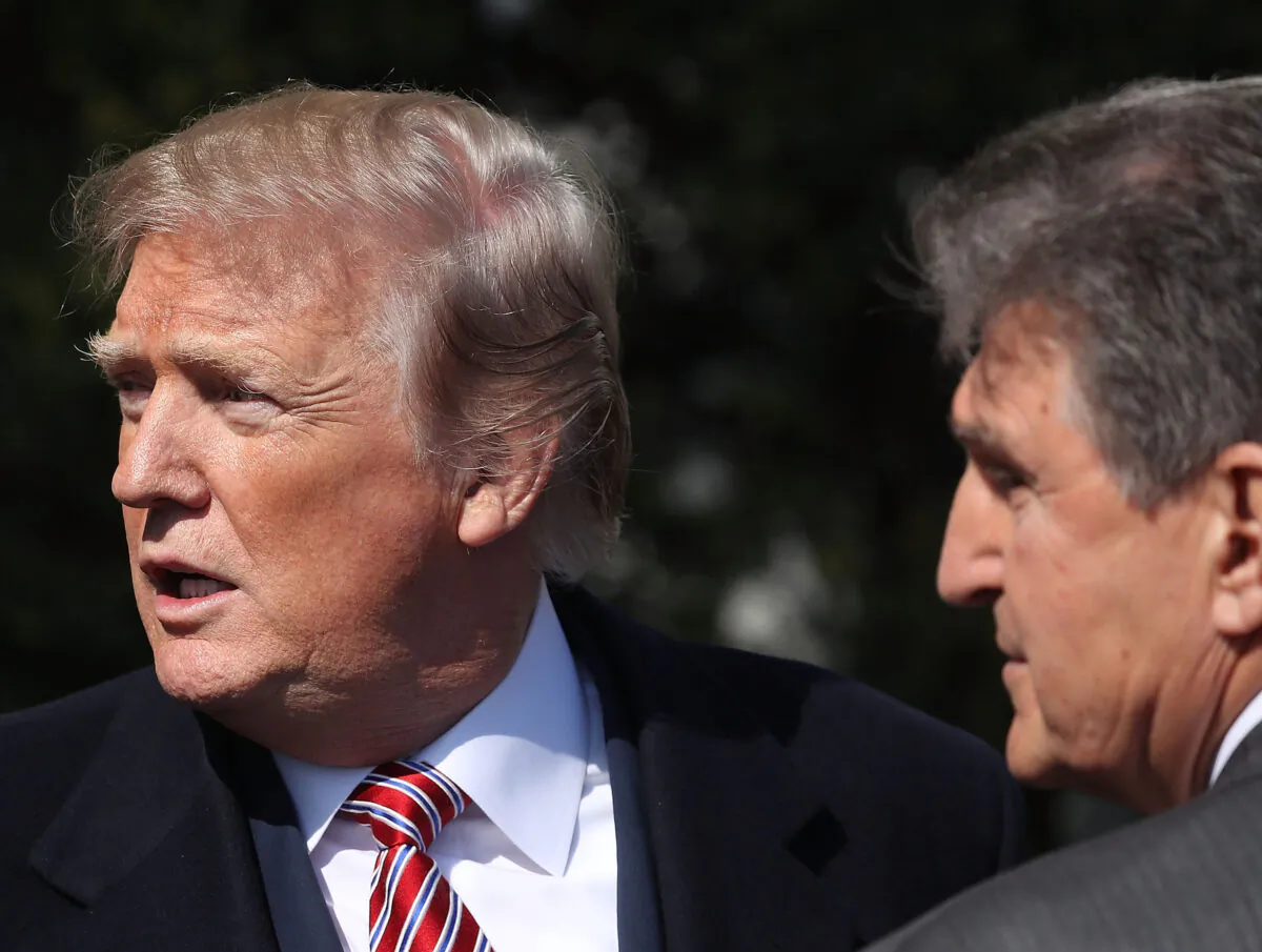 Then-President Donald Trump talks with Sen. Joe Manchin (D-W.Va.) during an event at the White House on April 10, 2019. (Mark Wilson/Getty Images)