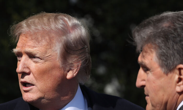 Then-President Donald Trump talks with Sen. Joe Manchin (D-W.Va.) during an event at the White House on April 10, 2019. (Mark Wilson/Getty Images)