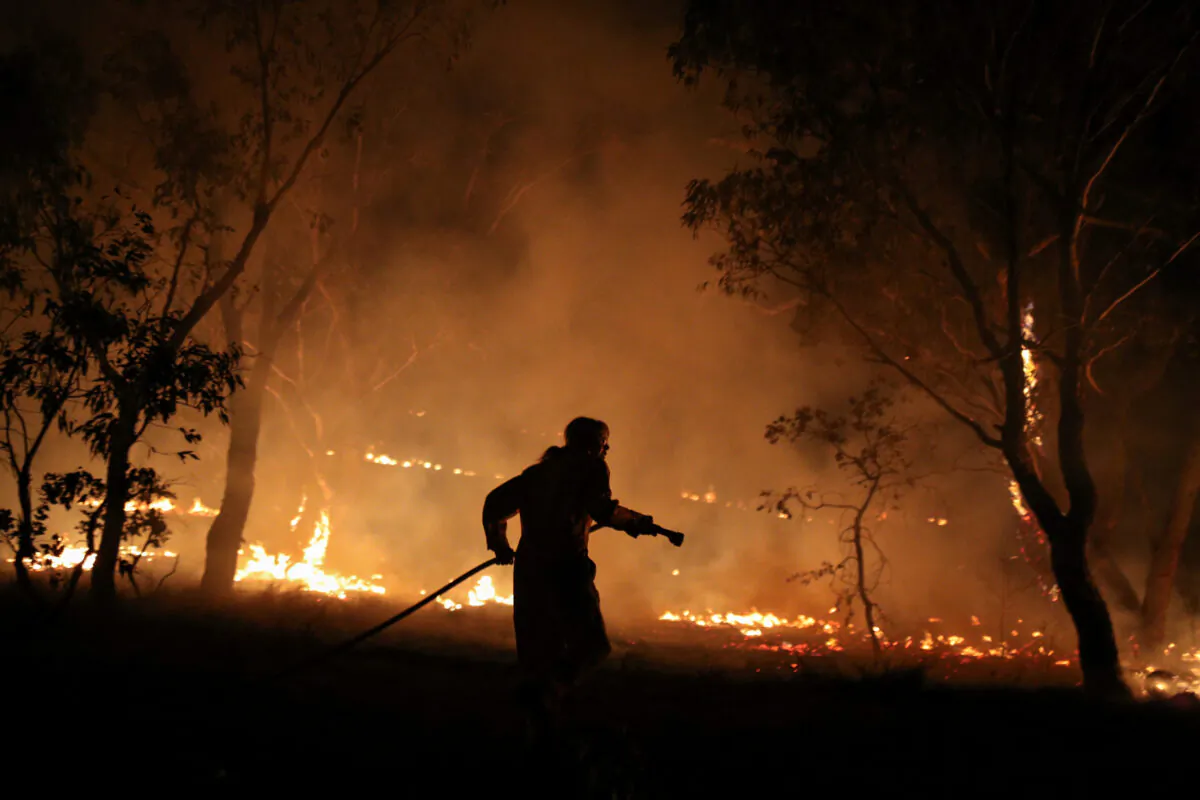 A firefighter from a local brigade works to extinguish flames after a bushfire burnt through the area in Bredbo, New South Wales, Australia, on Feb. 2, 2020.  (Loren Elliott/Reuters)