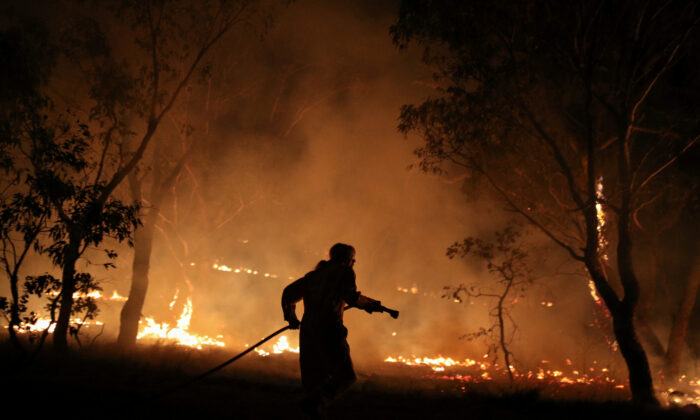 A firefighter from a local brigade works to extinguish flames after a bushfire burnt through the area in Bredbo, New South Wales, Australia, on Feb. 2, 2020.  (Loren Elliott/Reuters)