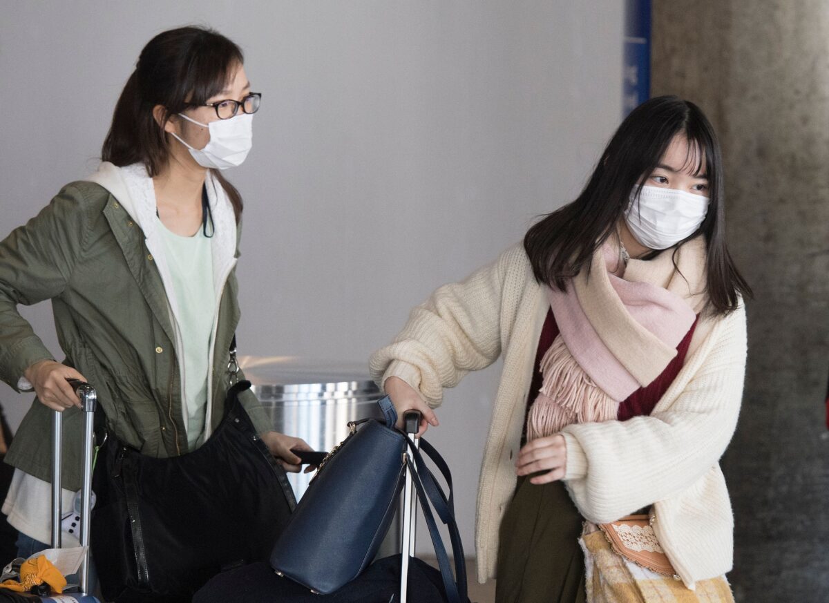Passengers wear face masks to protect against the spread of the Coronavirus