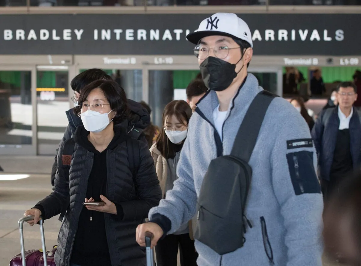 Passengers wear protective masks to protect against the spread of the Coronavirus as they arrive on a flight from Asia at the Los Angeles International Airport, Calif., on Jan. 29, 2020. (Mark Ralston/AFP via Getty Images)