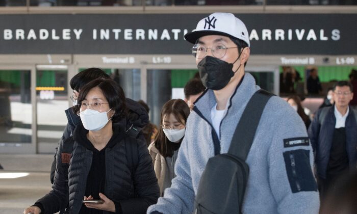 Passengers wear protective masks to protect against the spread of the Coronavirus as they arrive on a flight from Asia at the Los Angeles International Airport, Calif., on Jan. 29, 2020. (Mark Ralston/AFP via Getty Images)