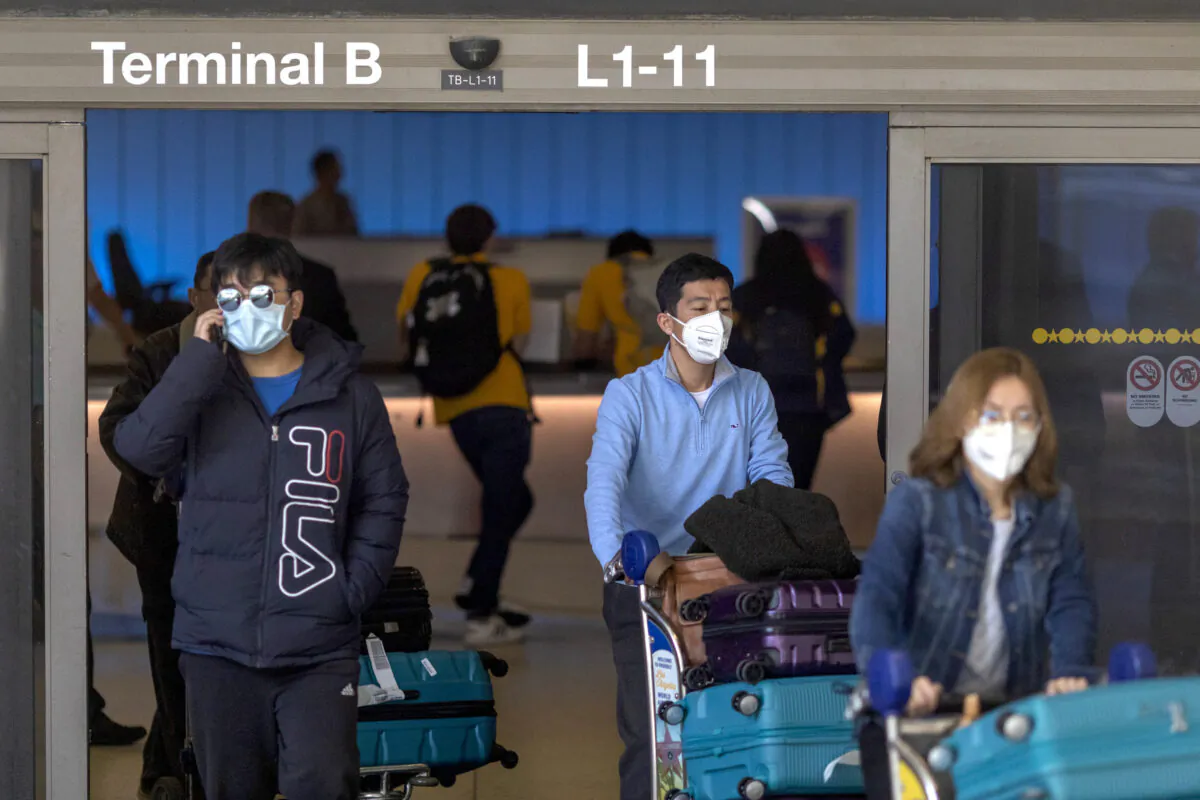 Travelers arrive to the Tom Bradley International Terminal at Los Angeles International Airport (LAX) wearing masks for protection against COVID-19 in Los Angeles, Calif., on Feb. 2, 2020. (David McNew/Getty Images)