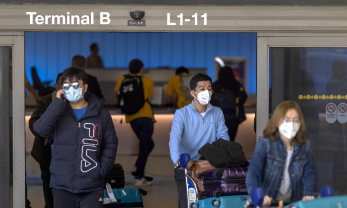 Travelers arrive to the Tom Bradley International Terminal at Los Angeles International Airport (LAX) wearing masks for protection against COVID-19 in Los Angeles, Calif., on Feb. 2, 2020. (David McNew/Getty Images)