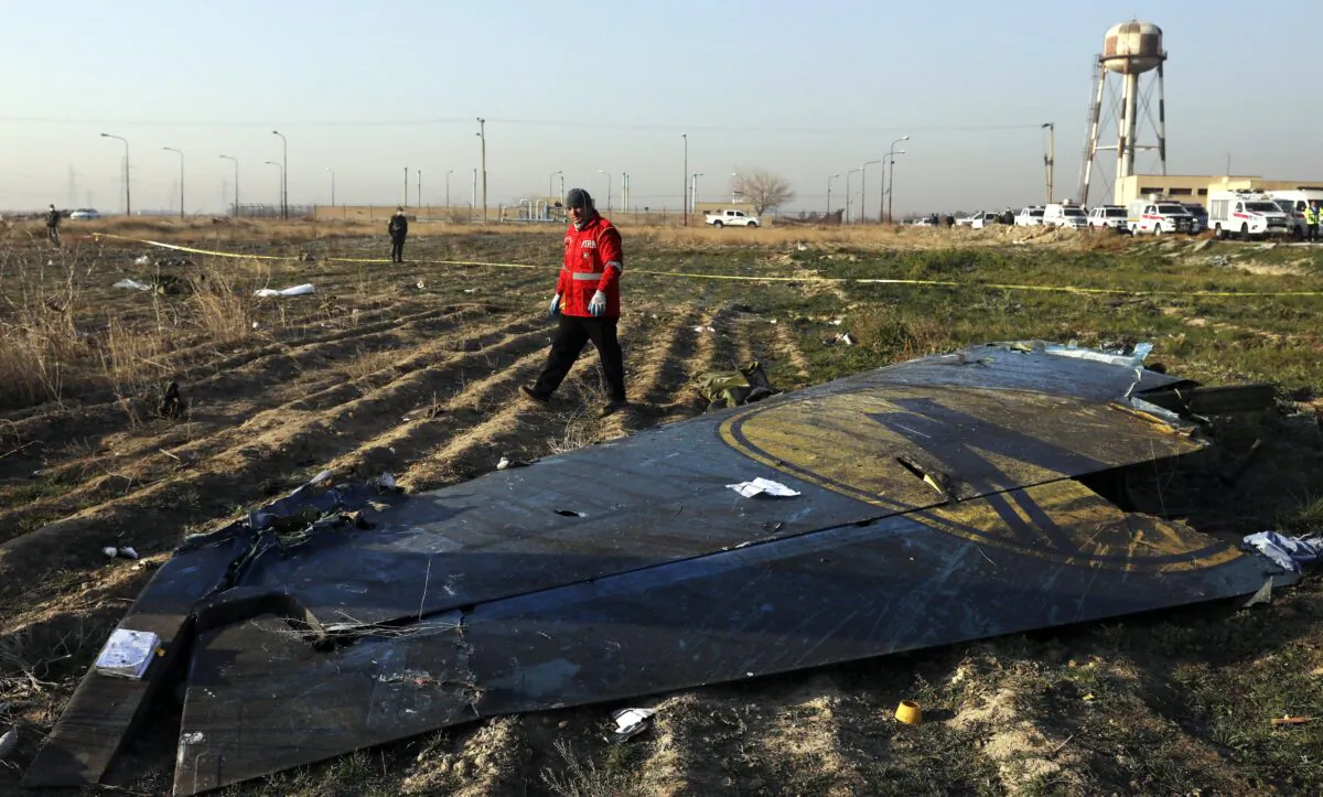 A rescue worker searches the scene on Jan. 8, 2020, where a Ukrainian plane crashed southwest of Tehran, Iran, killing all 176 people on board. (AP Photo/Ebrahim Noroozi)