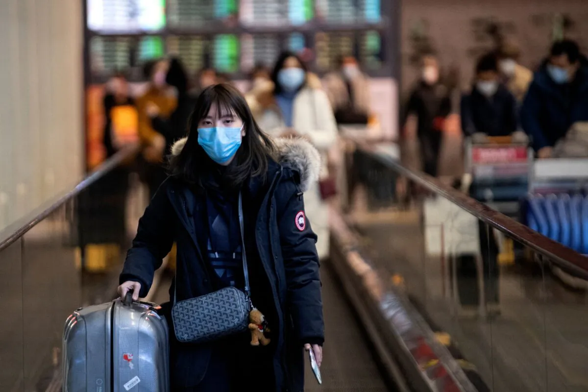 A passenger wearing a protective facemask arrives at the Beijing Capital International Airport in Beijing on Feb. 2, 2020. (Noel Celis/AFP via Getty Images)