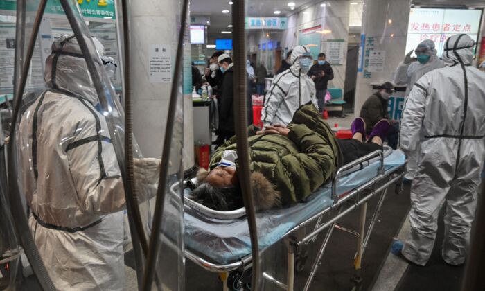 Medical staff members wearing protective clothing arrive with a patient at the Wuhan Red Cross Hospital in Wuhan, China, on Jan. 25, 2020. (Hector Retamal/AFP via Getty Images)