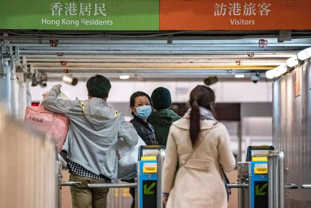Passengers cross the gate as they arrive at the Lo Wu MTR station, where one of the border checkpoints Hong Kong government announced to be shut down, on Feb. 3, 2020. (Anthony Kwan/Getty Images)