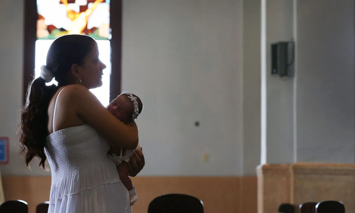A Cuban mother holds her baby as she visits the El Cobre church in Santiago de Cuba, Cuba, on Sept. 19, 2015. (Joe Raedle/Getty Images)