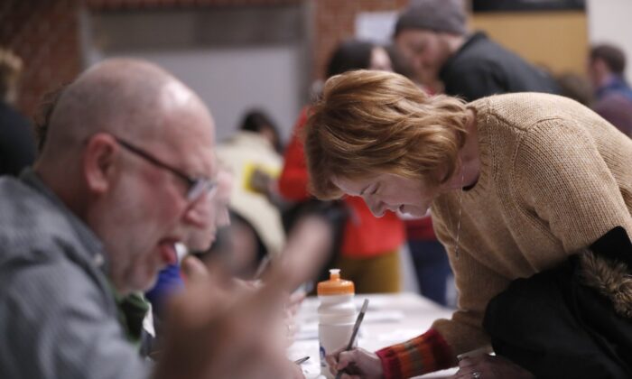 Caucus goers check in at Roosevelt Hight School, in Des Moines, Iowa, on Feb. 3, 2020. (Andrew Harnik/AP Photo)