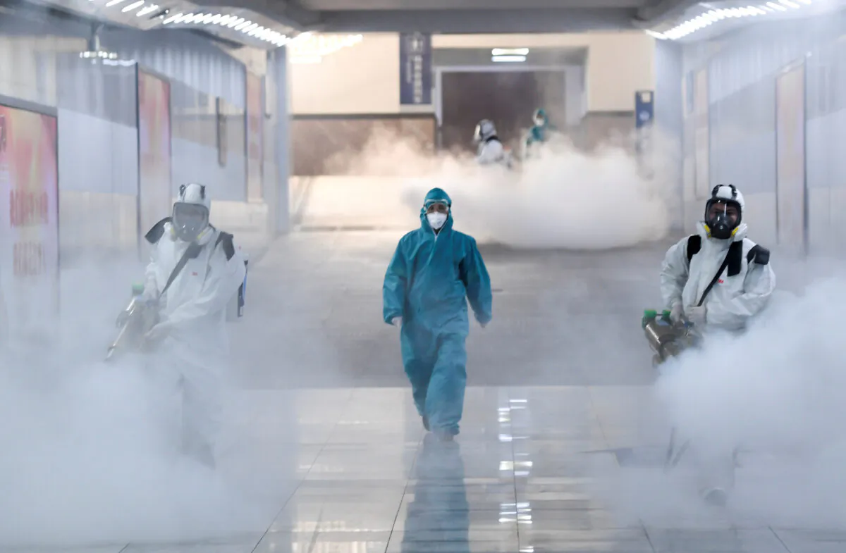 Volunteers in protective suits disinfect a railway station as the country is hit by an outbreak of the new coronavirus, in Changsha, Hunan Province, China on Feb. 4, 2020. (cnsphoto via Reuters)