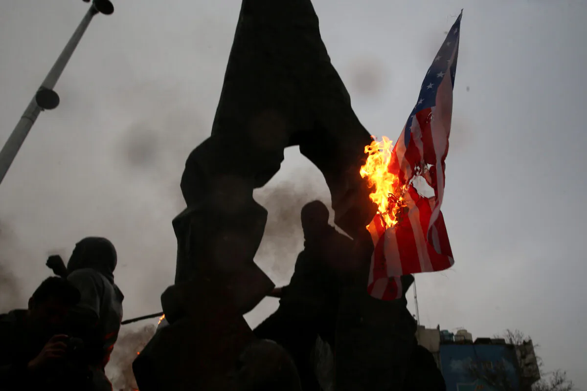 Iranians burn U.S and Israeli flags as they gather to mourn General Qassem Soleimani, head of the elite Quds Force, who was killed in an air strike at Baghdad airport, in Tehran, Iran Jan. 4, 2020. (Nazanin Tabatabaee/WANA (West Asia News Agency) via Reuters)