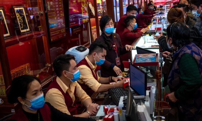 Gold shop employees wear face masks while serving customers in Hanoi, Vietnam, on Feb. 3, 2020. (Linh Pham via Getty Images)
