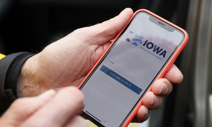 Precinct captain Carl Voss, of Des Moines, Iowa, holds his iPhone that shows the Iowa Democratic Party's caucus reporting app in Des Moines, Iowa, on Feb. 4, 2020. (Charlie Neibergall/AP Photo)