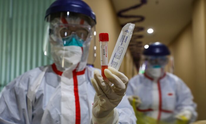 A medical staff member showing a test tube after taking samples from a person to be tested for the new coronavirus at a quarantine zone in Wuhan, China on Feb. 4, 2020. (STR/AFP via Getty Images)