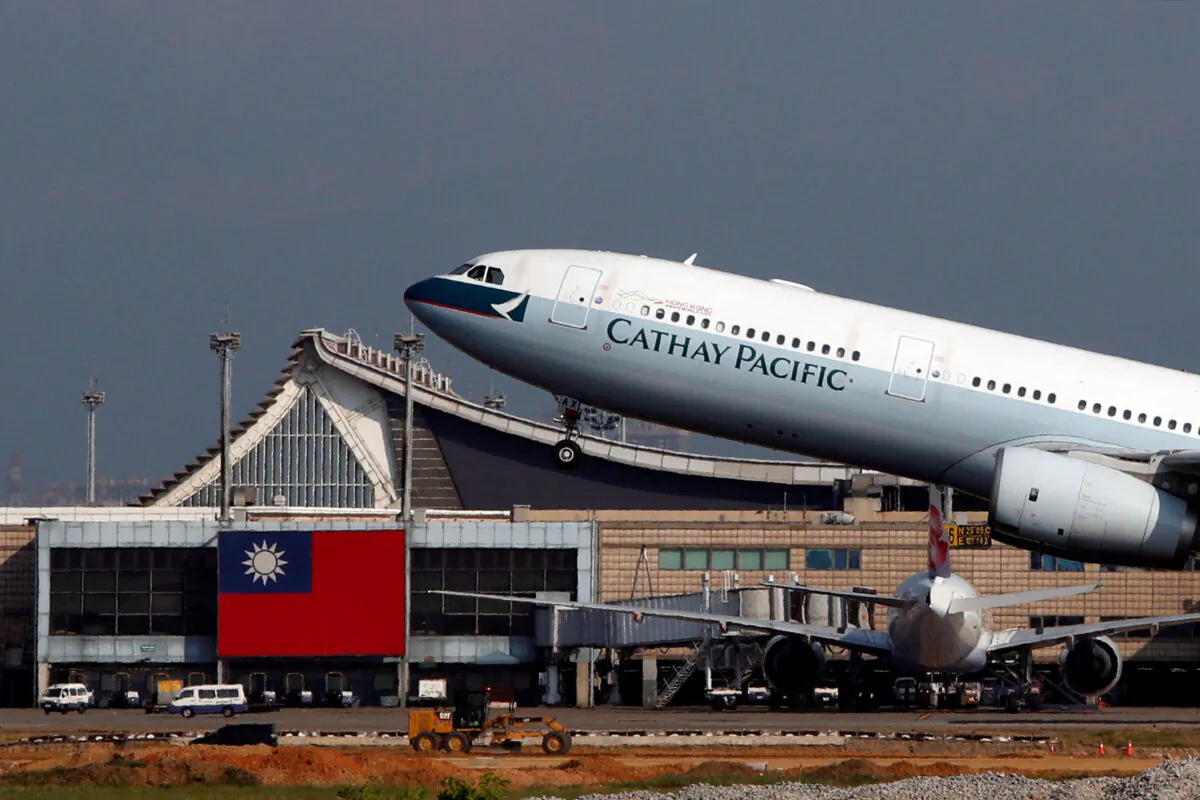 Hong Kong's Cathay Pacific Airways Airbus A330-300 passenger plane takes off near a Taiwanese national flag at Taoyuan International Airport, Taiwan on Aug. 6, 2018. (Tyrone Siu/Reuters)