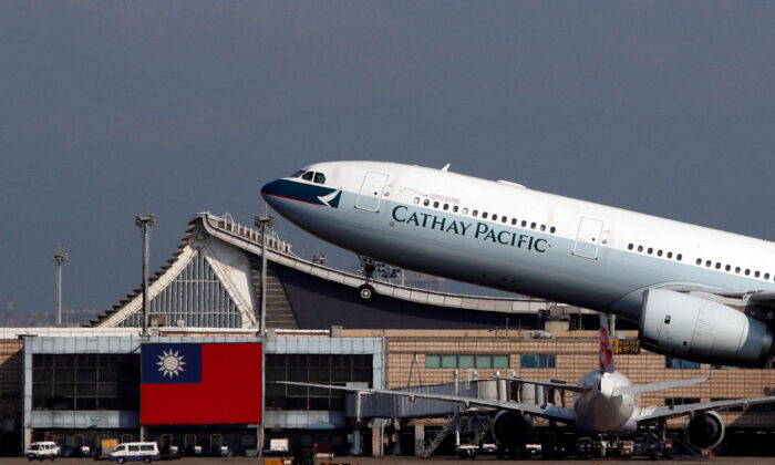 Hong Kong's Cathay Pacific Airways Airbus A330-300 passenger plane takes off near a Taiwanese national flag at Taoyuan International Airport, Taiwan on Aug. 6, 2018. (Tyrone Siu/Reuters)