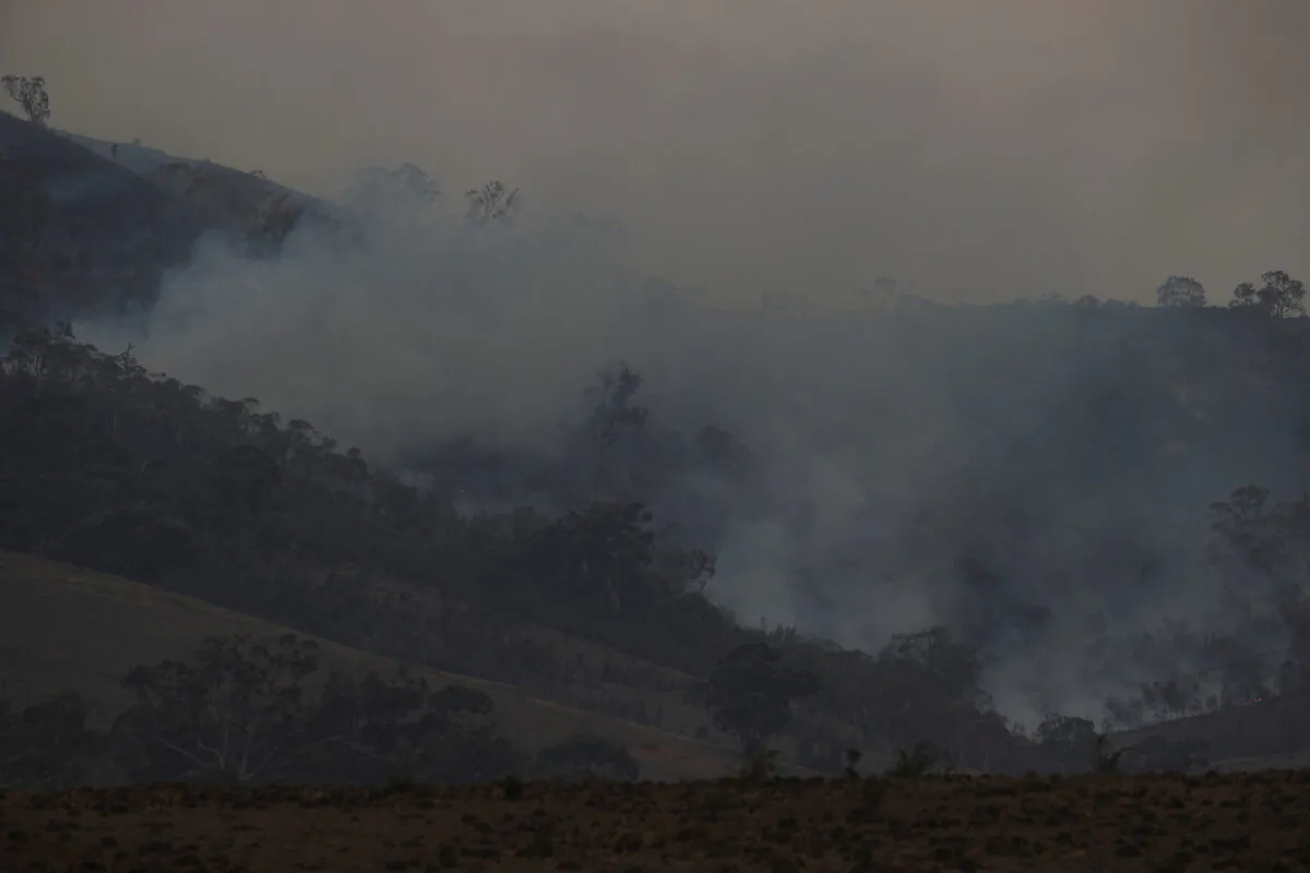 Smoke rises from the smouldering remnants of a bushfire near Bumbalong, New South Wales, Australia, Feb. 2, 2020.  (Loren Elliott/Reuters)