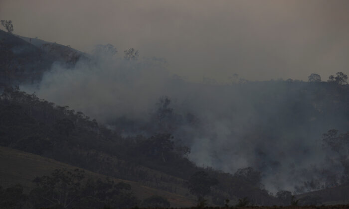 Smoke rises from the smouldering remnants of a bushfire near Bumbalong, New South Wales, Australia, Feb. 2, 2020.  (Loren Elliott/Reuters)