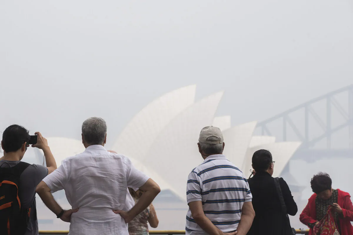 Tourists are seen taking photographs at Mrs Macquarie Point lookout in Sydney, Australia on Jan. 8, 2020. (Jenny Evans/Getty Images)
