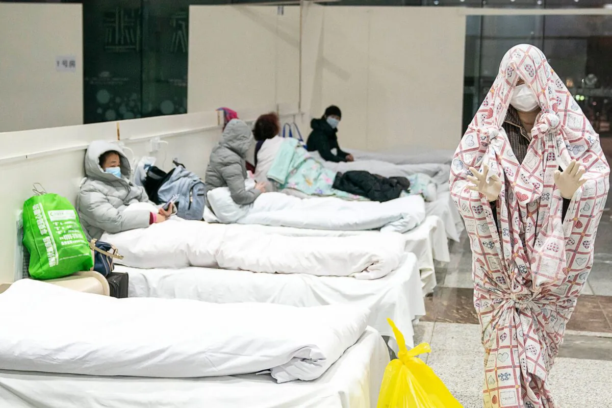 A patient covers with a bed sheet to make him warm at an exhibition centre converted Fangcang Hospital in Wuhan, China on Feb. 5, 2020. (STR/AFP via Getty Images)