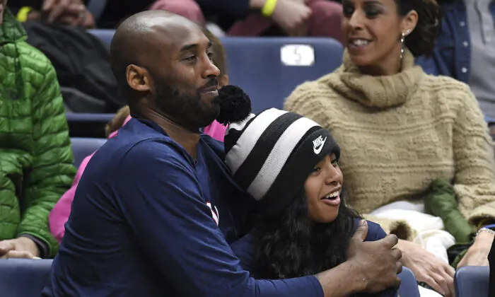 Kobe Bryant and his daughter Gianna watch the first half of an NCAA college basketball game between Connecticut and Houston in Storrs, Conn., on March 2, 2019. (Jessica Hill/AP Photo)