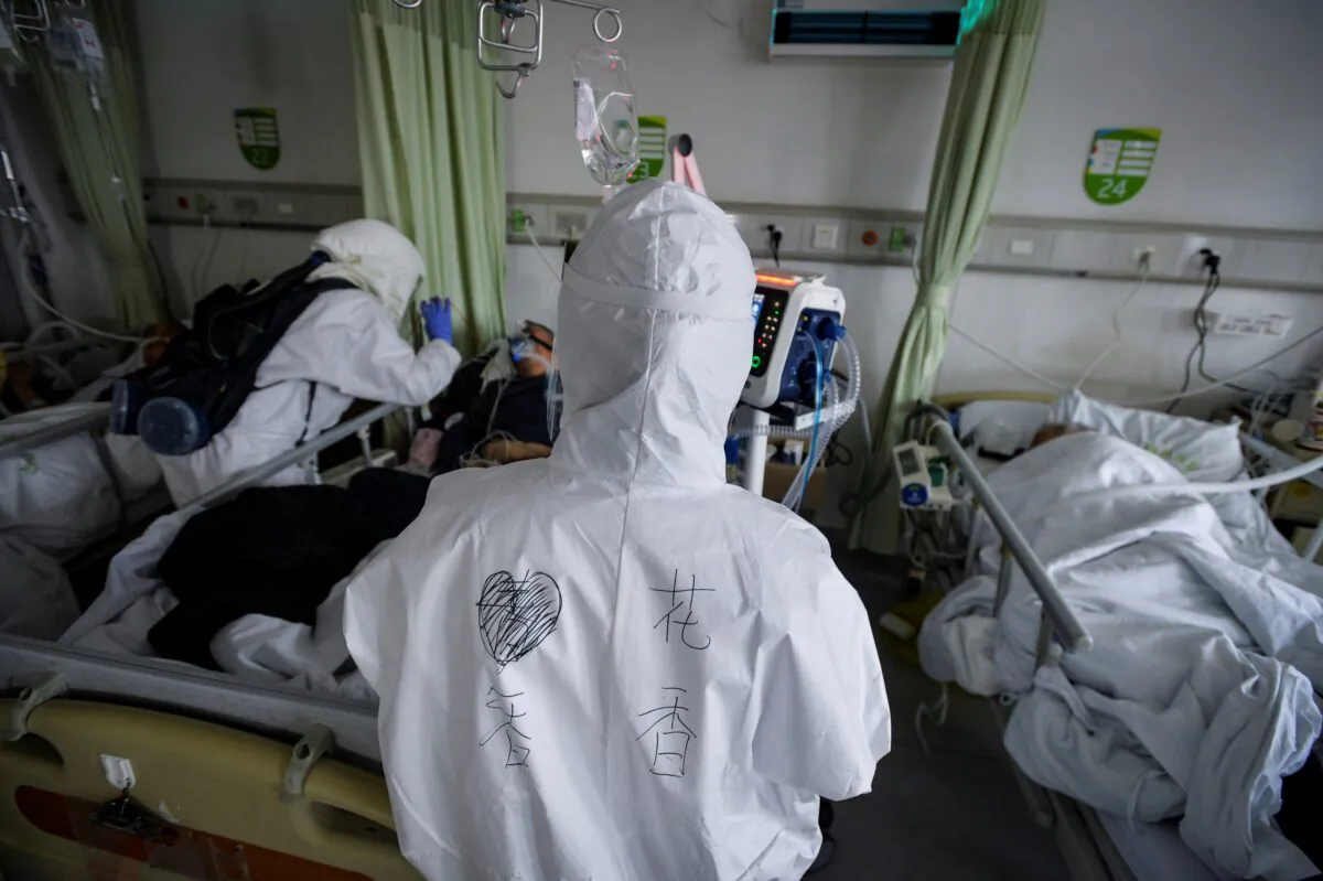 Medical workers in protective suits attend to patients with the new coronavirus inside an isolated ward at a hospital in Wuhan, Hubei province, China, on Feb. 6, 2020. (China Daily via Reuters)