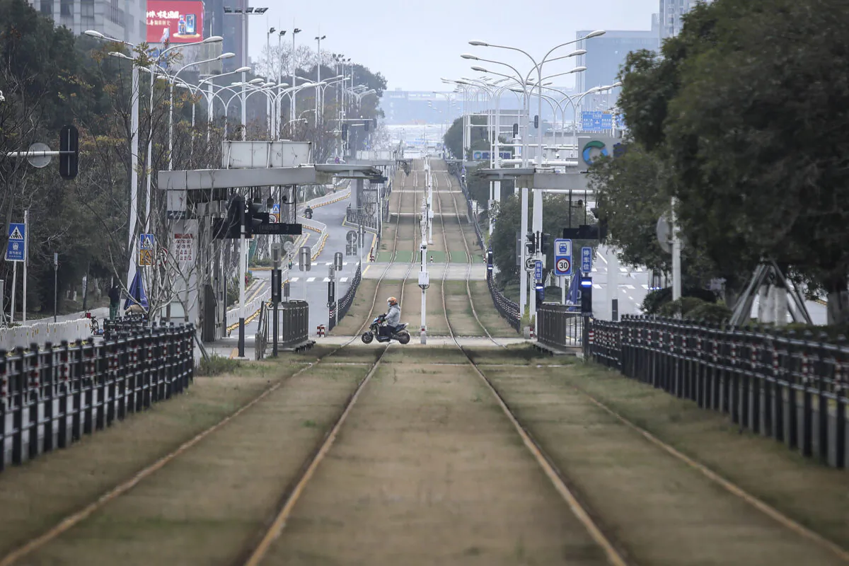 A resident rides a motorbike across an empty track in Wuhan, Hubei Province, China on Feb. 7, 2020. Starting from Jan. 23, 2020, Wuhan was placed under strict lockdown for 76 days. (Getty Images)