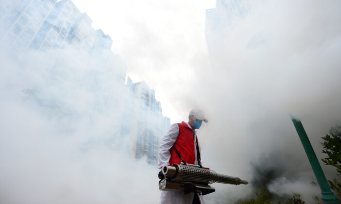 A volunteer disinfects a residential compound to prevent and control the new coronavirus, in Ganzhou, Jiangxi province, China on Feb. 6, 2020. (China Daily via Reuters)