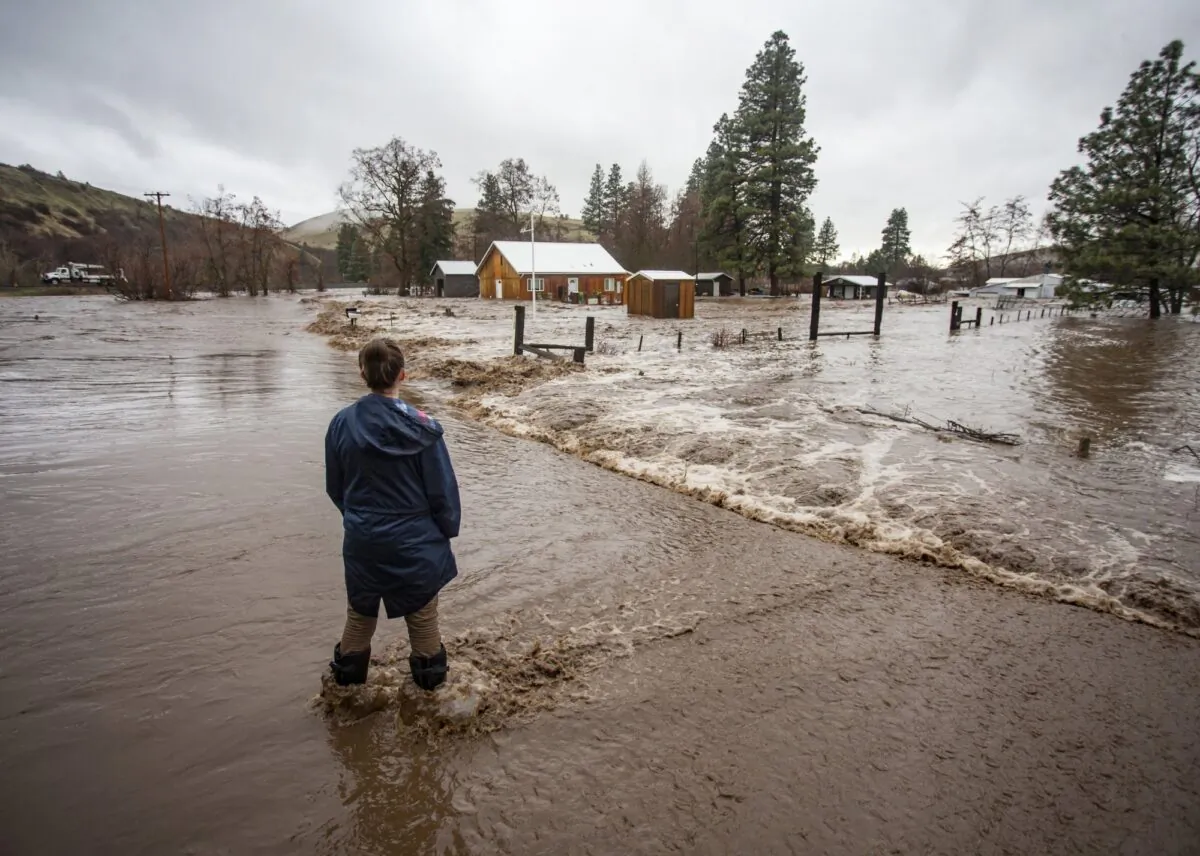 Chantel Fuller watches as water floods her home in Thorn Hollow outside of Adams, Ore., on Feb. 6, 2020. (Ben Lonergan/East Oregonian via AP)