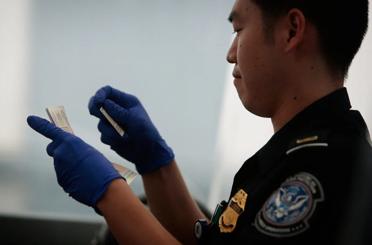 A United States Customs and Border Protection officer checks checks two forms of identification for a traveler arriving from overseas into Newark International Airport in Newark, N.J., Aug. 24, 2009. (Chris Hondros/Getty Images)