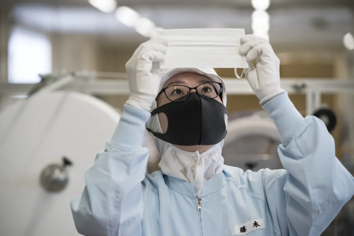 An employee inspects a disposable face mask on the production line of the Yokoi Co. Ltd. factory in Nagoya, Japan on Feb. 06, 2020. (Tomohiro Ohsumi/Getty Images)
