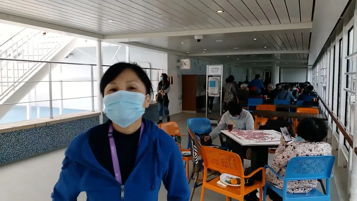 Passengers wear protective masks aboard the World Dream cruise ship, being quarantined at Kai Tak Cruise Terminal amid concerns of coronavirus infections, in Hong Kong, China on Feb. 8, 2020 in this still image obtained from social media video. (Dr. Peter Lo via Reuters)