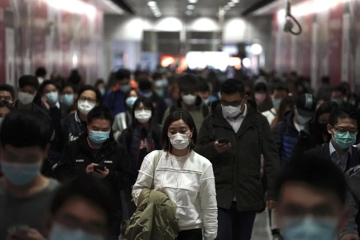 People wearing masks, walk in a subway station in Hong Kong on Feb. 7, 2020. (AP Photo/Kin Cheung)