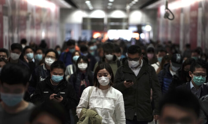 People wearing masks, walk in a subway station in Hong Kong on Feb. 7, 2020. (AP Photo/Kin Cheung)