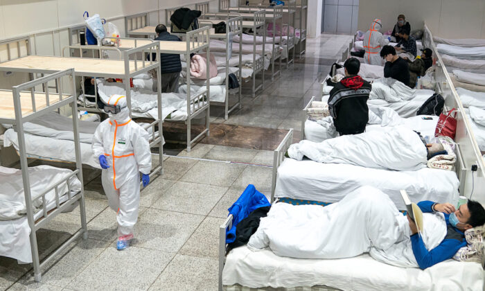 Medical workers in protective suits attend to patients at the Wuhan International Conference and Exhibition Center, which has been converted into a makeshift hospital to receive patients with mild symptoms caused by the novel coronavirus, in Wuhan, Hubei province, China on Feb. 5, 2020. (China Daily via Reuters)