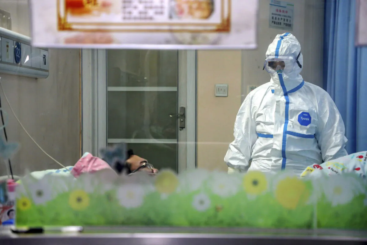 A doctor attends to a patient in an isolation ward at a hospital in Wuhan in central China's Hubei Province, on Jan. 30, 2020. (Chinatopix via AP)